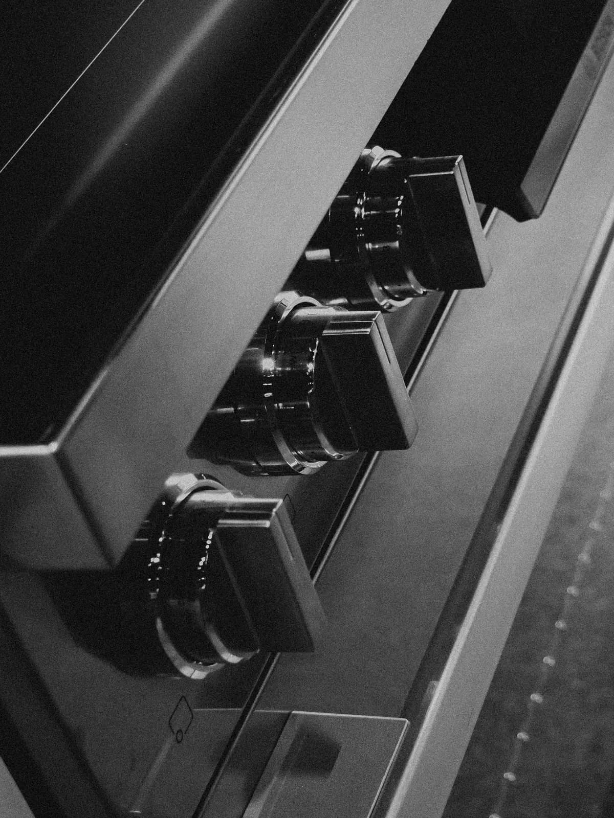 Close-up of black oven control knobs on a stainless control panel