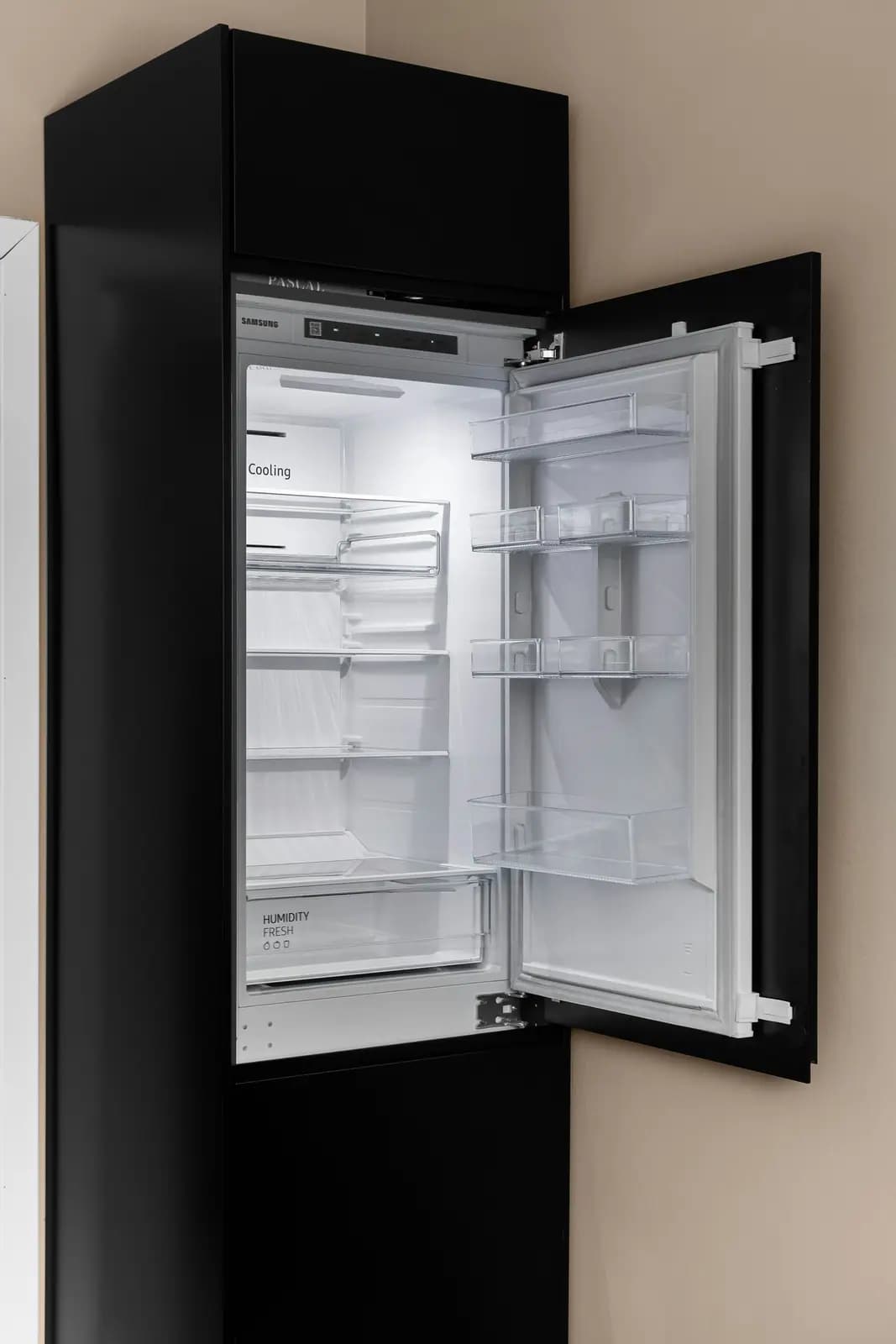 Empty refrigerator interior with glass shelves and door bins