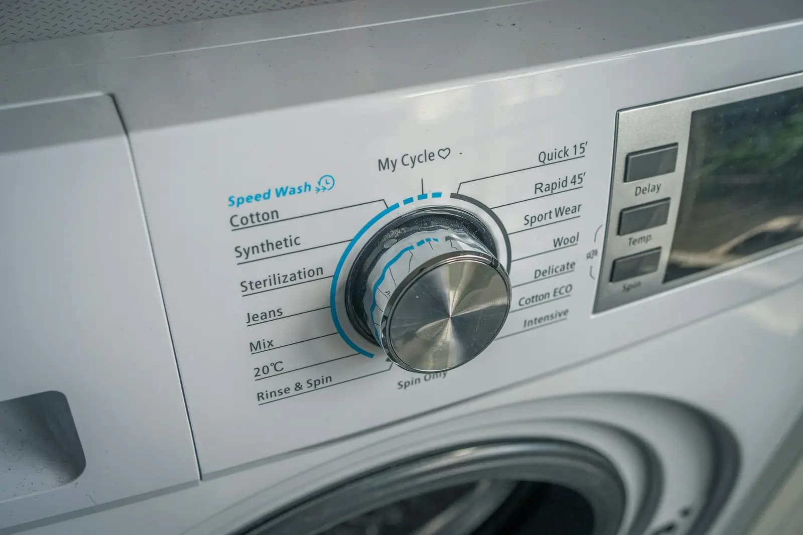 Close-up of a washer cycle-selection dial and control panel