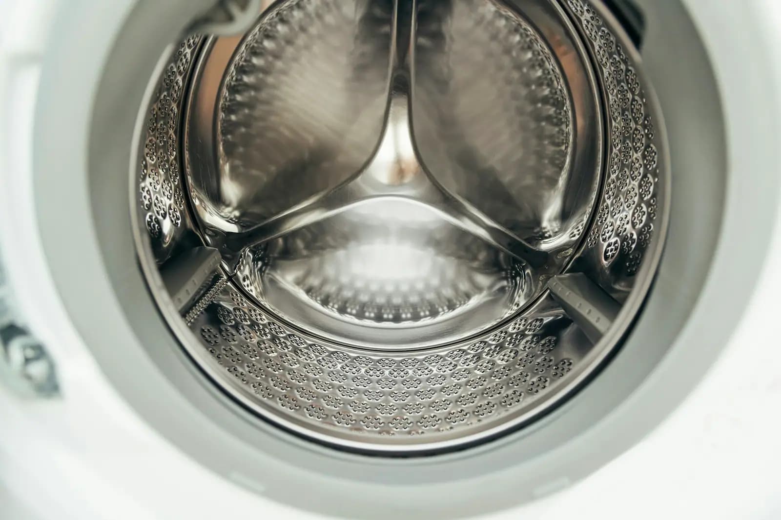 Stainless steel drum of a front-load washer seen through the open door