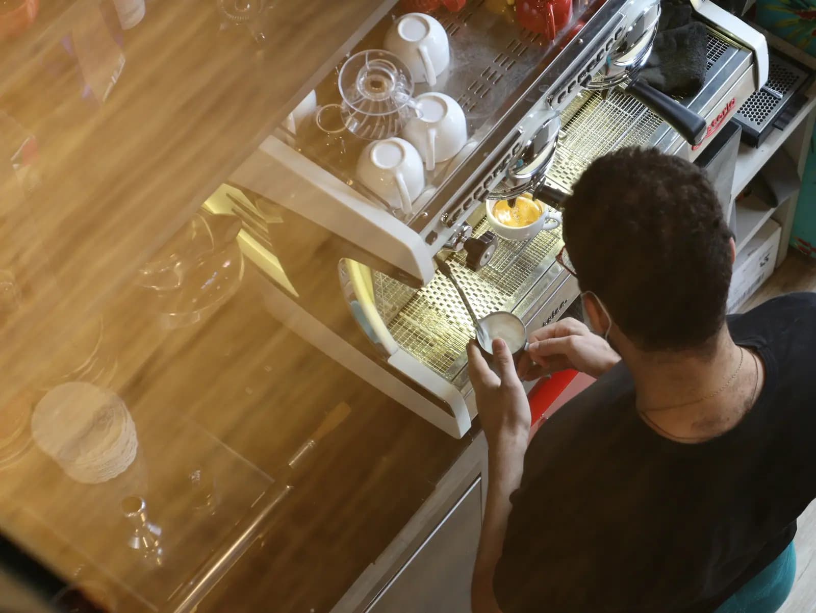 Person checking glassware on a pulled-out dishwasher rack